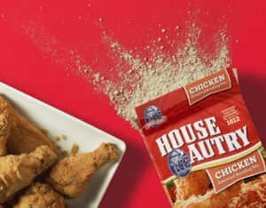 An open box of House Autry seasoning next to a plate of fried chicken