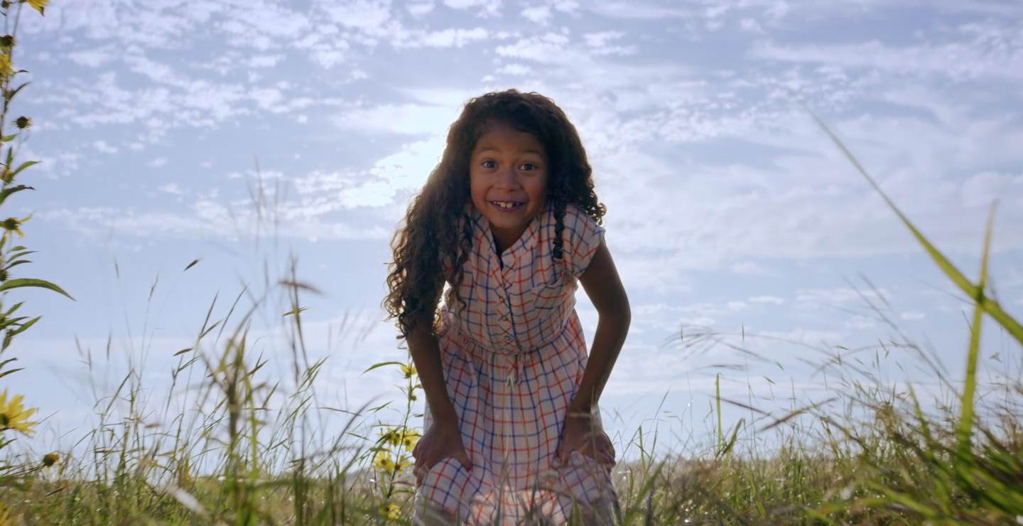 Little girl smiling in an open field